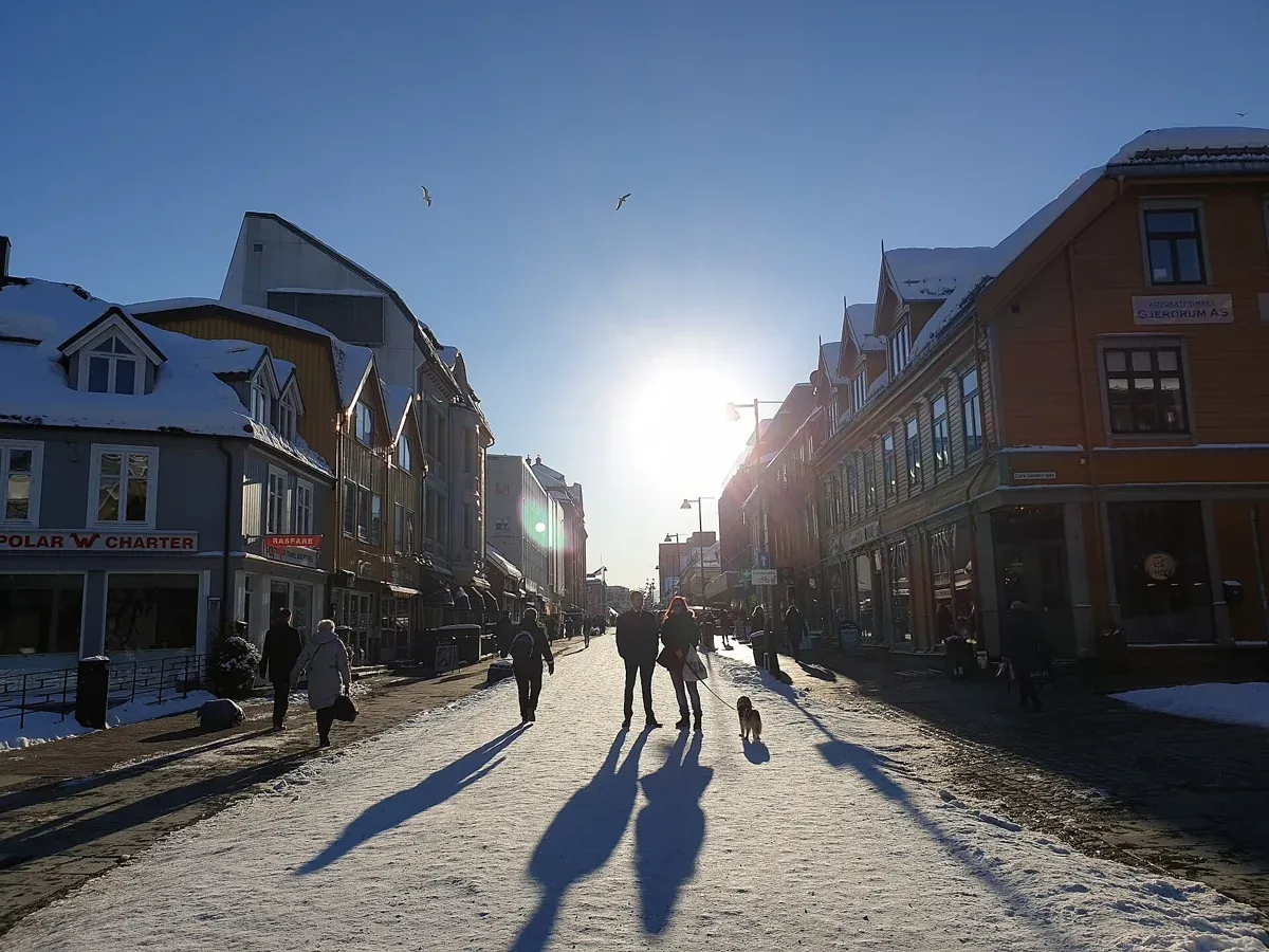Low winter sun and icy pavement on Storgata in Tromsø, street conditions to dress for around Tromso reindeer sledding